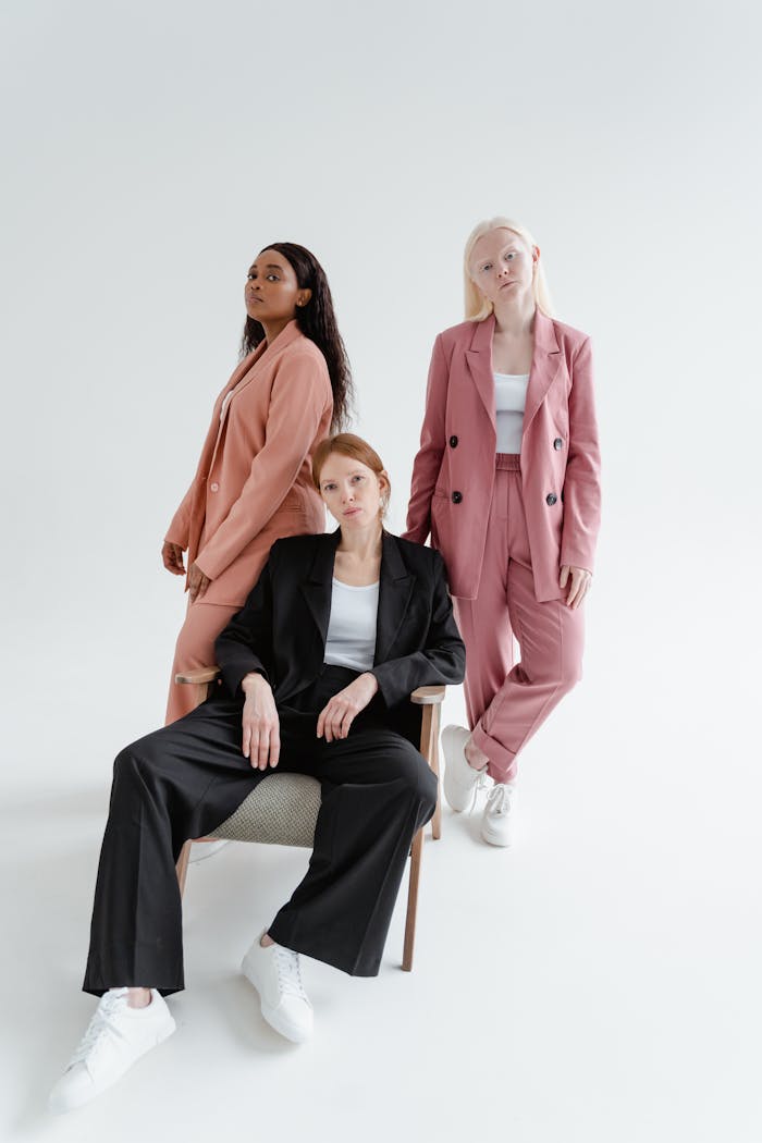 heros-img Three stylish women in blazers posing confidently in a bright studio setting.